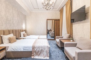 A hotel room with two beds, a sofa, a TV, and a mirror. - Safir Hotel  (Fergana)