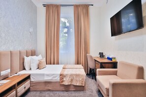 A hotel room with a bed, a desk, a chair, and a TV. - Safir Hotel  (Fergana)