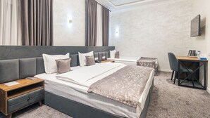 A modern hotel room with a large bed, a desk, and a chair. - Safir Hotel  (Fergana)