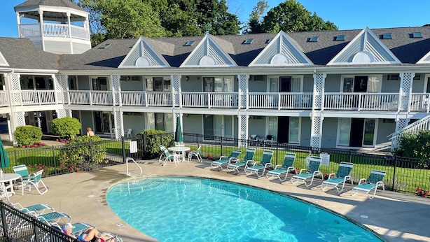 Ein Hotel mit einem großen Schwimmbad, mehreren Balkonen und Außenbereichen zum Sitzen.