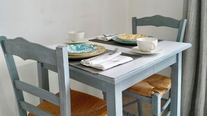 A dining table with two chairs, a framed picture above, and a window with curtains. - Sam’s cottage, a peaceful Provencal Retreat, minutes from famous Thoronet Abbey. (Le Thoronet)