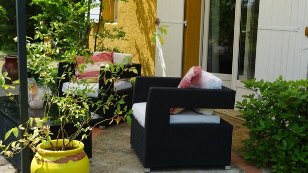 An outdoor patio with a covered seating area, a large planter, and a door leading to a covered entrance. - Sam’s cottage, a peaceful Provencal Retreat, minutes from famous Thoronet Abbey. (Le Thoronet)