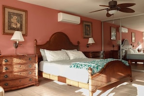 A bedroom with a wooden bed, a dresser, and a ceiling fan.