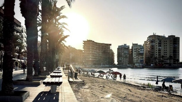 A riverside promenade with benches, palm trees, and buildings in the background. - Playa del Cura, 3 min to the beach, Central, Free parking (Torrevieja)