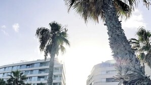 A modern building with multiple floors and a curved facade, surrounded by palm trees. - Playa del Cura, 3 min to the beach, Central, Free parking (Torrevieja)