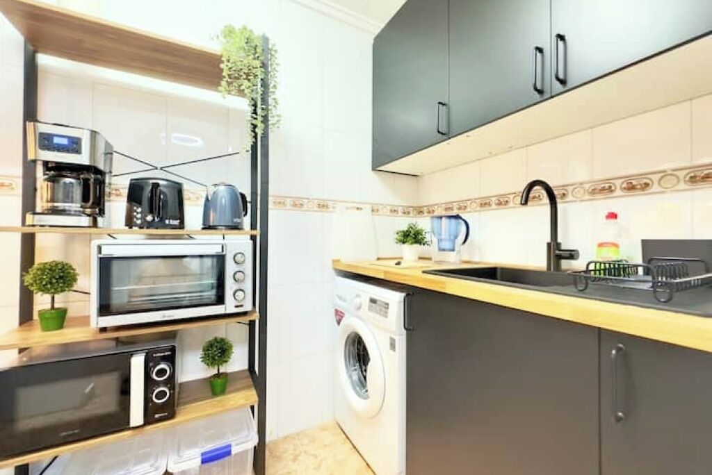 Cocina compacta con microondas, tostadora y lavadora.