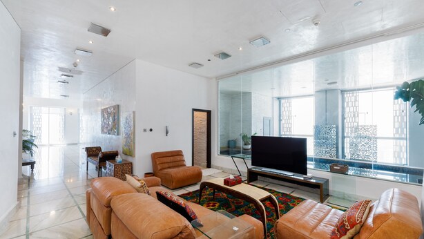 A spacious living room with a large flat-screen TV, leather sofas, and a glass coffee table. - Elegant 4BR Marina Penthouse Private Pool (Dubai)