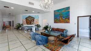 A spacious living area with a modern chandelier, a large painting, and a sofa set. - Elegant 4BR Marina Penthouse Private Pool (Dubai)