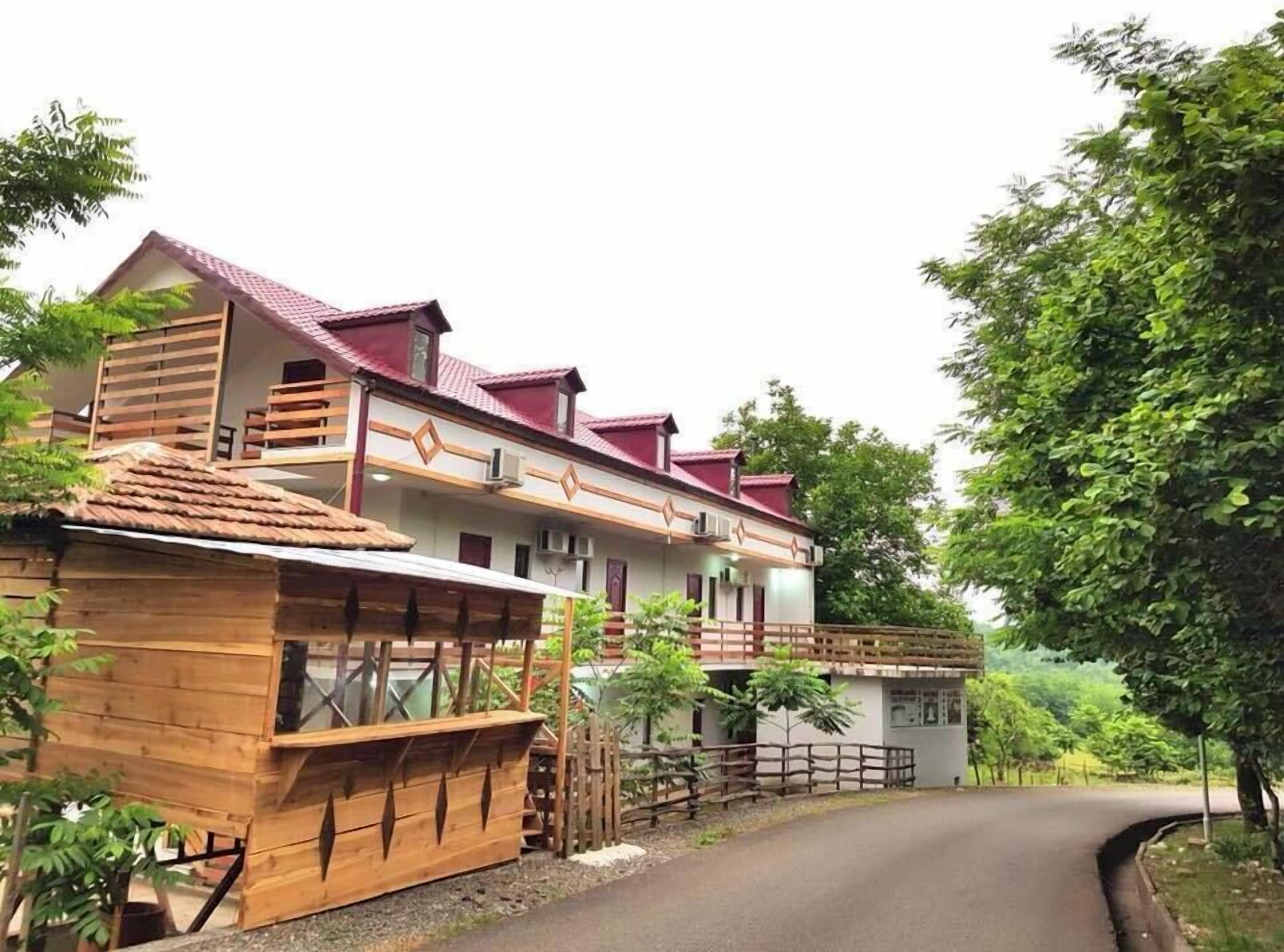 A two-story building with a red roof and wooden balconies.