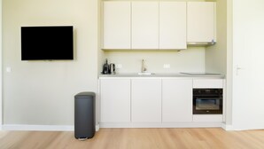 A modern kitchen with white cabinets, a built-in oven, and a black trash bin. - Tranquil Holiday Home With Views (Oud Ade)
