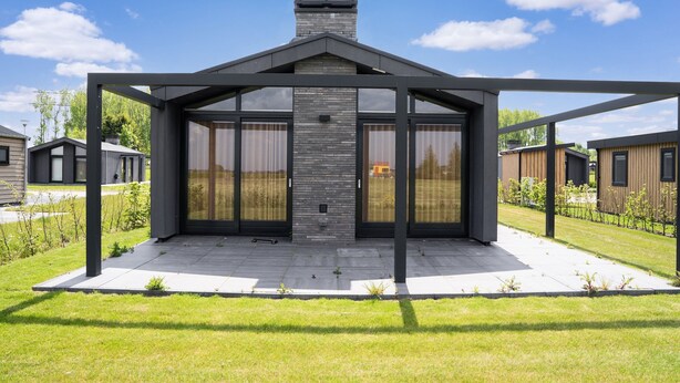 A modern house with a large glass door and a chimney. - Tranquil Holiday Home With Views (Oud Ade)