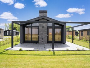 A modern house with a large glass door and a chimney. - Tranquil Holiday Home With Views (Oud Ade)