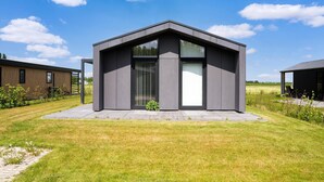 A modern, single-story building with a flat roof and large windows. - Tranquil Holiday Home With Views (Oud Ade)