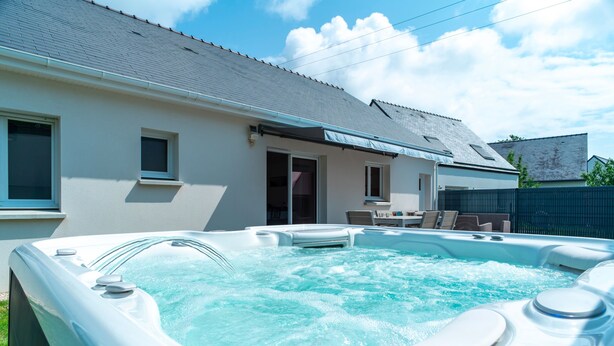 A hot tub in a backyard with a house in the background. - La Bulle de Landrezac - Jacuzzi/Proche Plage (Sarzeau)