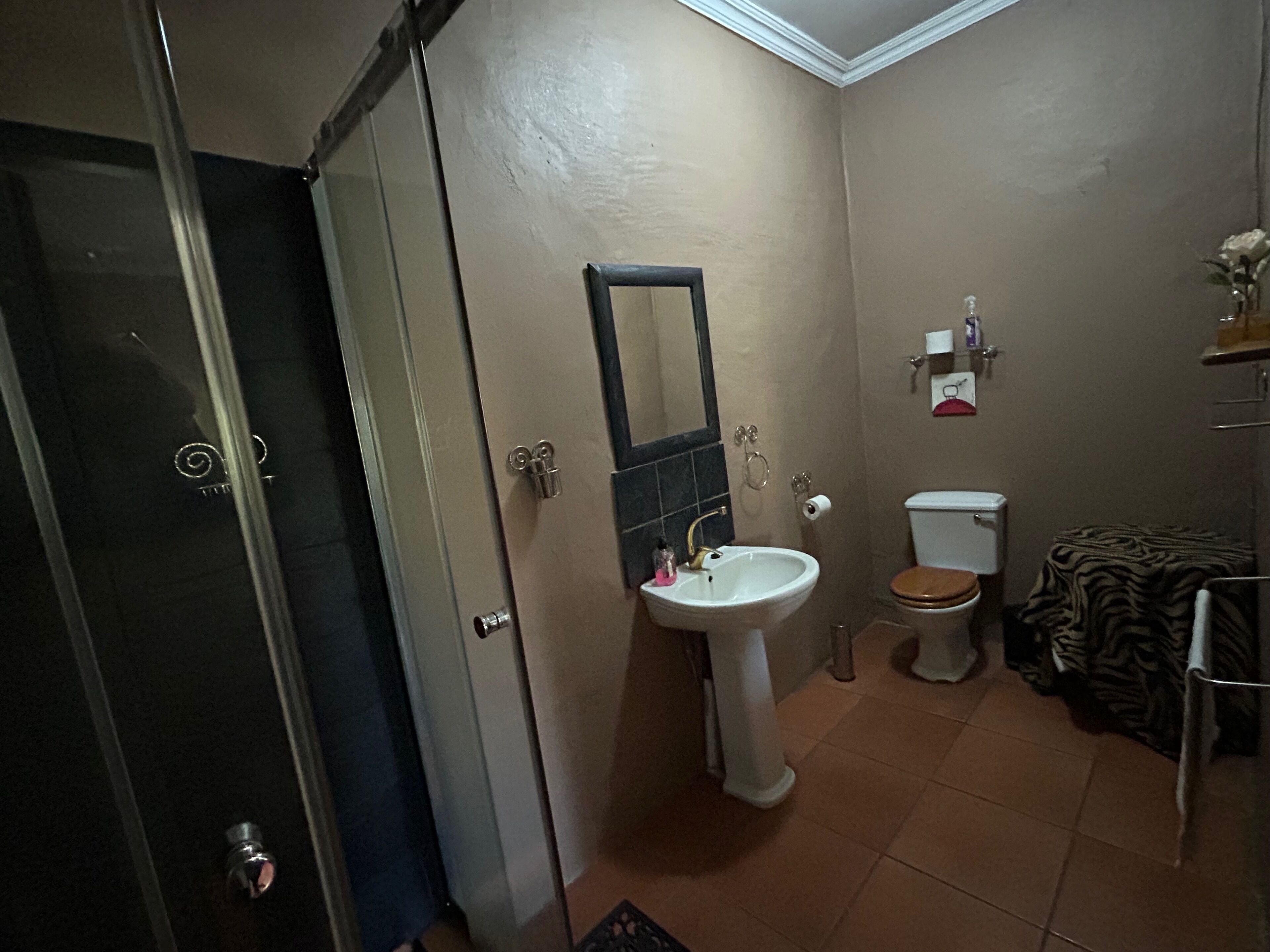 Un baño con lavamanos, inodoro y espejo.