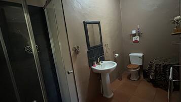 Un baño con lavamanos, inodoro y espejo.