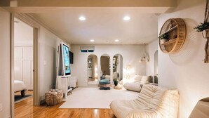 A modern living room with a sofa, a television, and a large mirror.