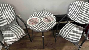 A dining area with four chairs and a small round table, each with a black and white chevron pattern. - Cozy Coastal Cabin w/Hot Tub (Valley Road)