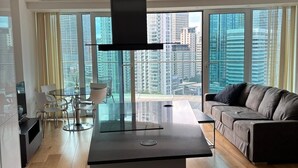 A modern living room with a large window, a central black table, and a sofa. - Luxury Stay with Scenic Views (London)