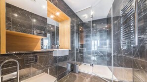 A modern bathroom with a toilet, sink, and glass shower enclosure. - Luxury Stay with Scenic Views (London)