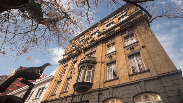 A historic building with a brick facade, large windows, and a prominent corner entrance.