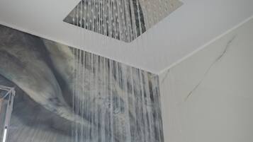 A modern shower with a square design and a waterfall feature.
