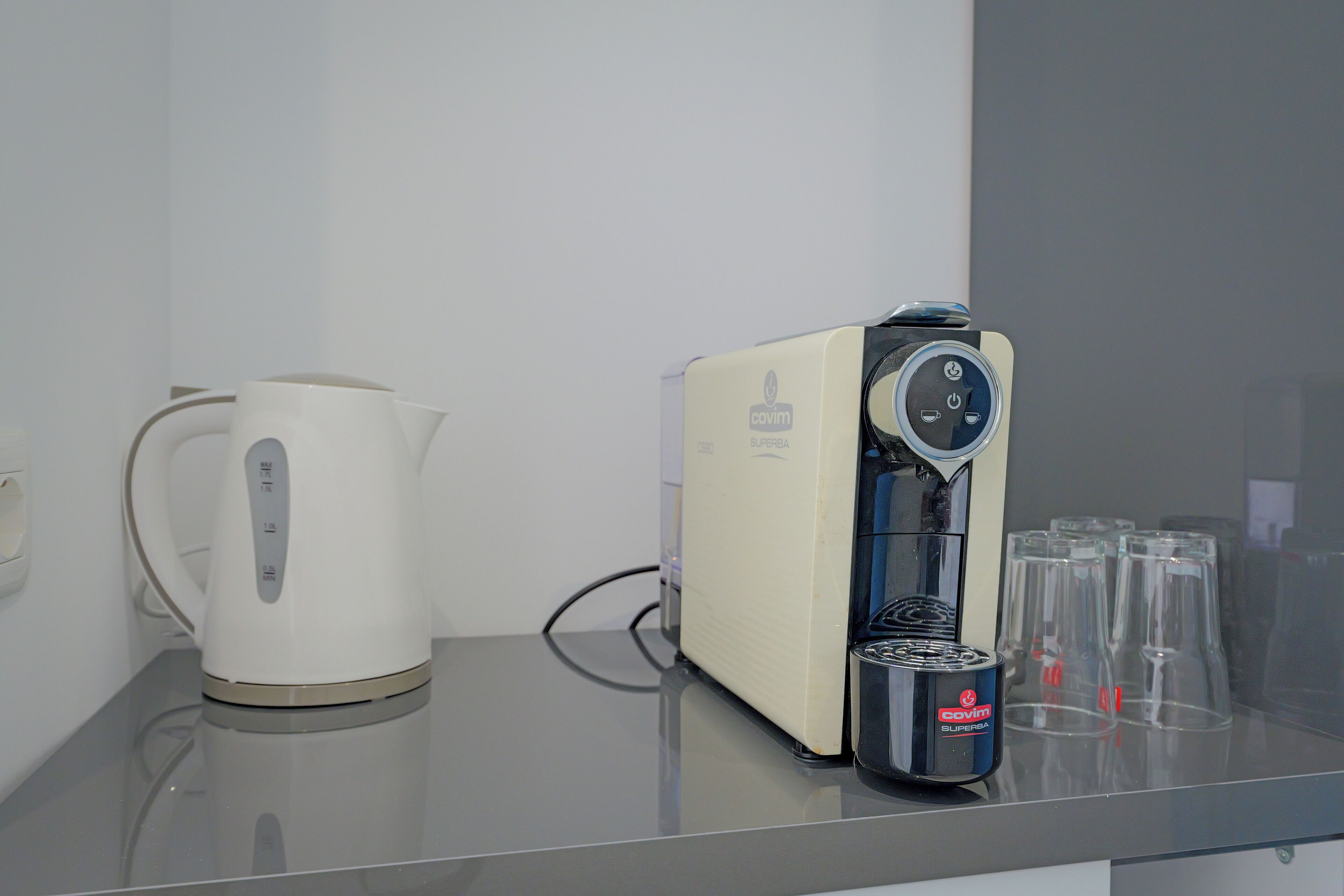 Eine Kaffeemaschine und ein Wasserkocher auf einem Tisch.