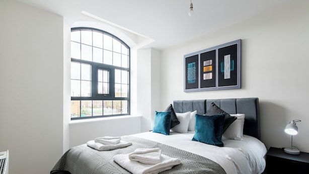 A modern hotel room with a large bed, a window, and artwork on the wall. - The Glassworks (Nottingham)