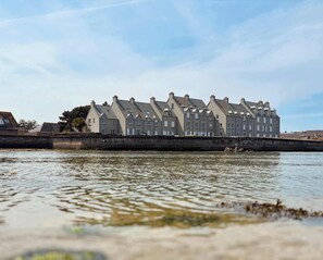 A row of uniform, multi-story buildings by a body of water. - Les pieds dans l eau Home - Waterfront Stay (Barfleur)