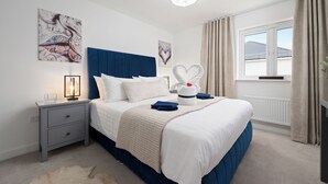 A neatly arranged bedroom with a bed, bedside table, and a window with curtains. - Stylish 3-Bed Retreat with Hot Tub & Garden | Near Perth City Centre (Perth)