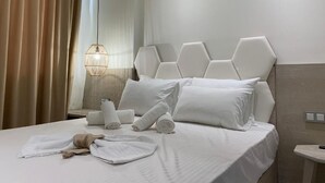 Een hotelkamer met een bed, een wit hoofdeinde en een nachtkastje met een lamp.