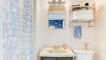Ein Badezimmer mit Waschbecken, Spiegel, Handtuchhalter und Toilette.
