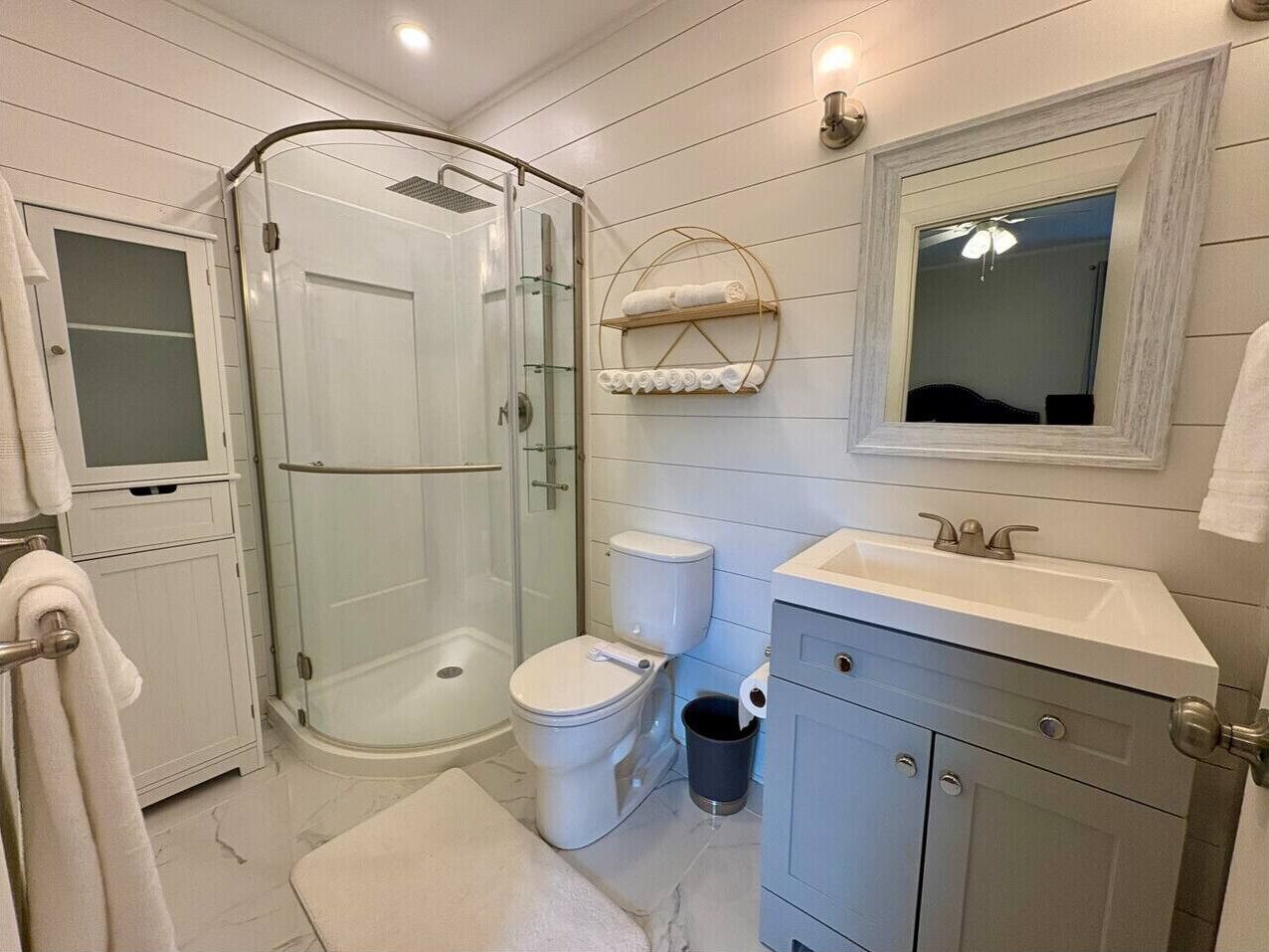 Ein modernes Badezimmer mit Duschkabine, Toilette, Waschbecken und Waschtisch.