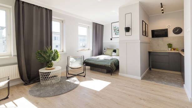 Un appartement moderne comprenant un lit, un coin repas et une cuisine.