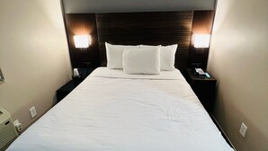 A hotel room with a large bed, two bedside tables, and two wall-mounted lamps. - Rockaway Hotel Brooklyn (Brooklyn)