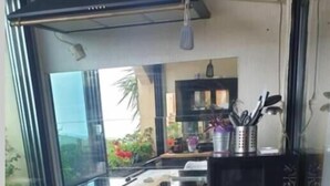 Une cuisine compacte dotée d’un plan de travail en bois, d’un four à micro-ondes et d’un petit meuble de rangement.