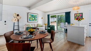 A modern kitchen with a dining area, featuring a wooden table, chairs, and a kitchen island.