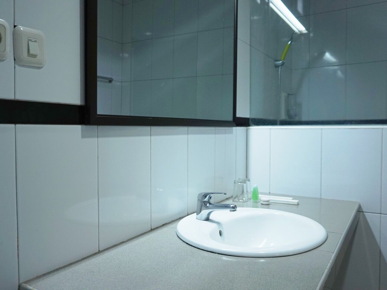 A bathroom with a white sink, a mirror, and a shower.