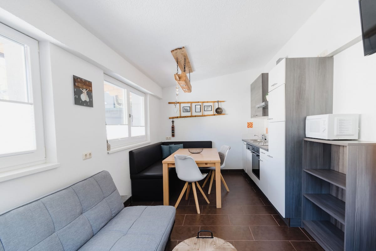 Una cucina compatta con zona pranzo, forno integrato e microonde.