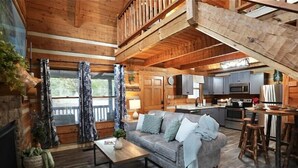 Interior acogedor de una cabaña con sala de estar, cocina y comedor.
