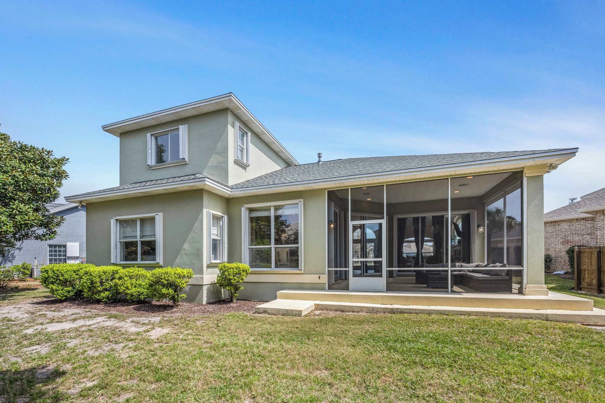 A modern two-story house with a covered porch, large windows, and a well-maintained lawn.