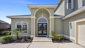 A two-story house with a front entrance, a garage, and a landscaped front yard. - Private Beach & Community Pool (Miramar Beach)