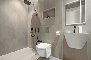 Une salle de bain moderne équipée d’une douche, de toilettes et d’un lavabo.
