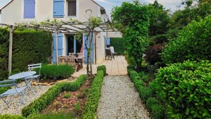 A two-story house with a garden patio, a pergola, and a gravel pathway. - Holiday Home in Perigord Noir Near Dordogne (Carsac-Aillac)