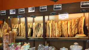A bakery display with various types of bread and pastries, including baguettes and a sign indicating a price of 0.10€ for a tranchage. - Holiday Home in Perigord Noir Near Dordogne (Carsac-Aillac)