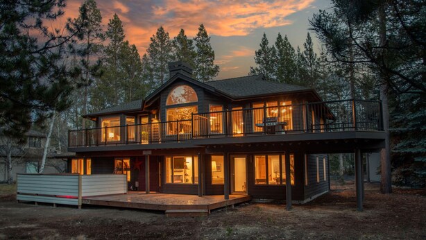 A large, two-story house with a balcony and large windows, surrounded by trees. - Blue Goose in Sunriver Resort (Sunriver)