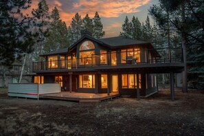 A large, two-story house with a balcony and large windows, surrounded by trees. - Blue Goose in Sunriver Resort -with SHARC Passes (Sunriver)