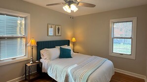 A bedroom with a bed, two bedside tables with lamps, a ceiling fan, and two windows with blinds. - Charming 3-bedroom house with AC and WiFi in Appleton (Appleton)