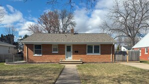 A two-story brick house with a front porch, a front yard, and a sidewalk leading to the front door. - Charming 3-bedroom house with AC and WiFi in Appleton (Appleton)