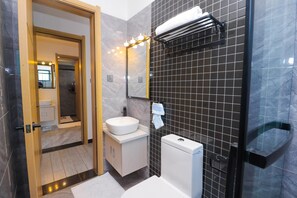 Een douche, handdoeken, zeep, toiletpapier